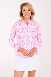 Woman wearing a long sleeve sun shirt with mesh sleeves in a pink and white splatter print.