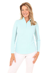 Woman wearing a light blue long-sleeve shirt with a white background