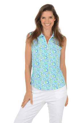Woman wearing a sleeveless patterned top and white pants on a white background. Second front shot.