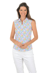Woman wearing a colorful sleeveless patterned top and white pants on a white background.