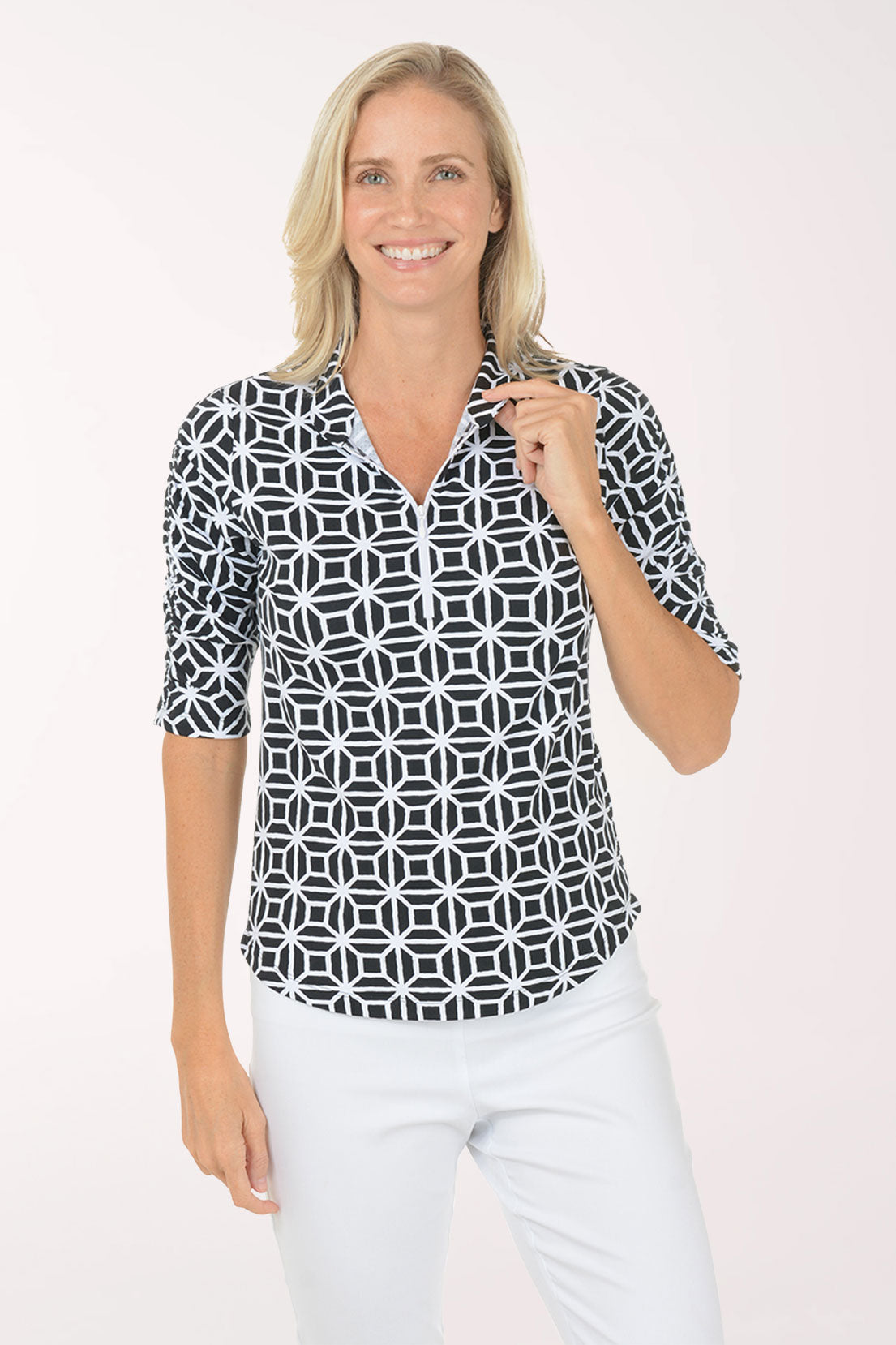 Woman wearing a black and white patterned shirt with a plain background