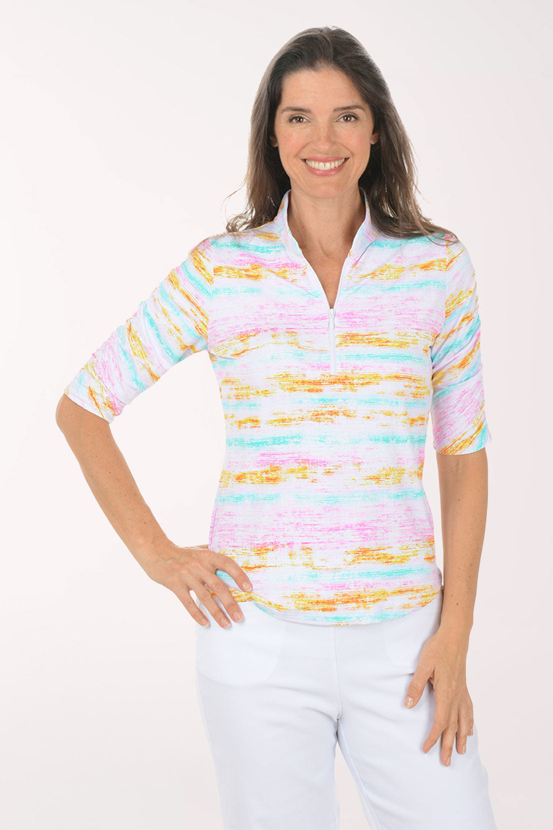 Woman wearing a colorful striped shirt and white pants on a white background