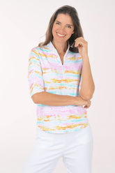 Woman wearing a colorful striped shirt and white pants on a white background