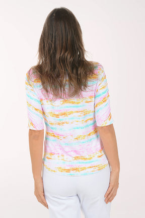 Woman wearing a colorful striped shirt and white pants on a white background