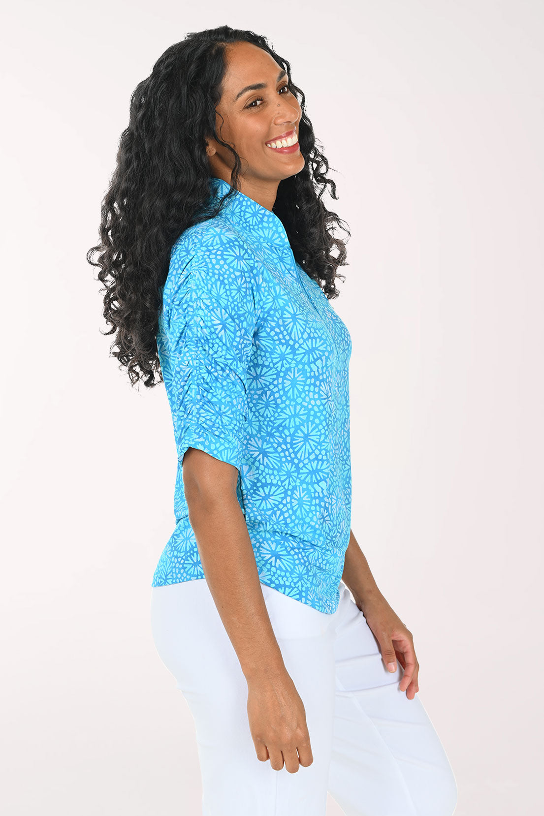 Woman wearing a blue patterned shirt against a white background