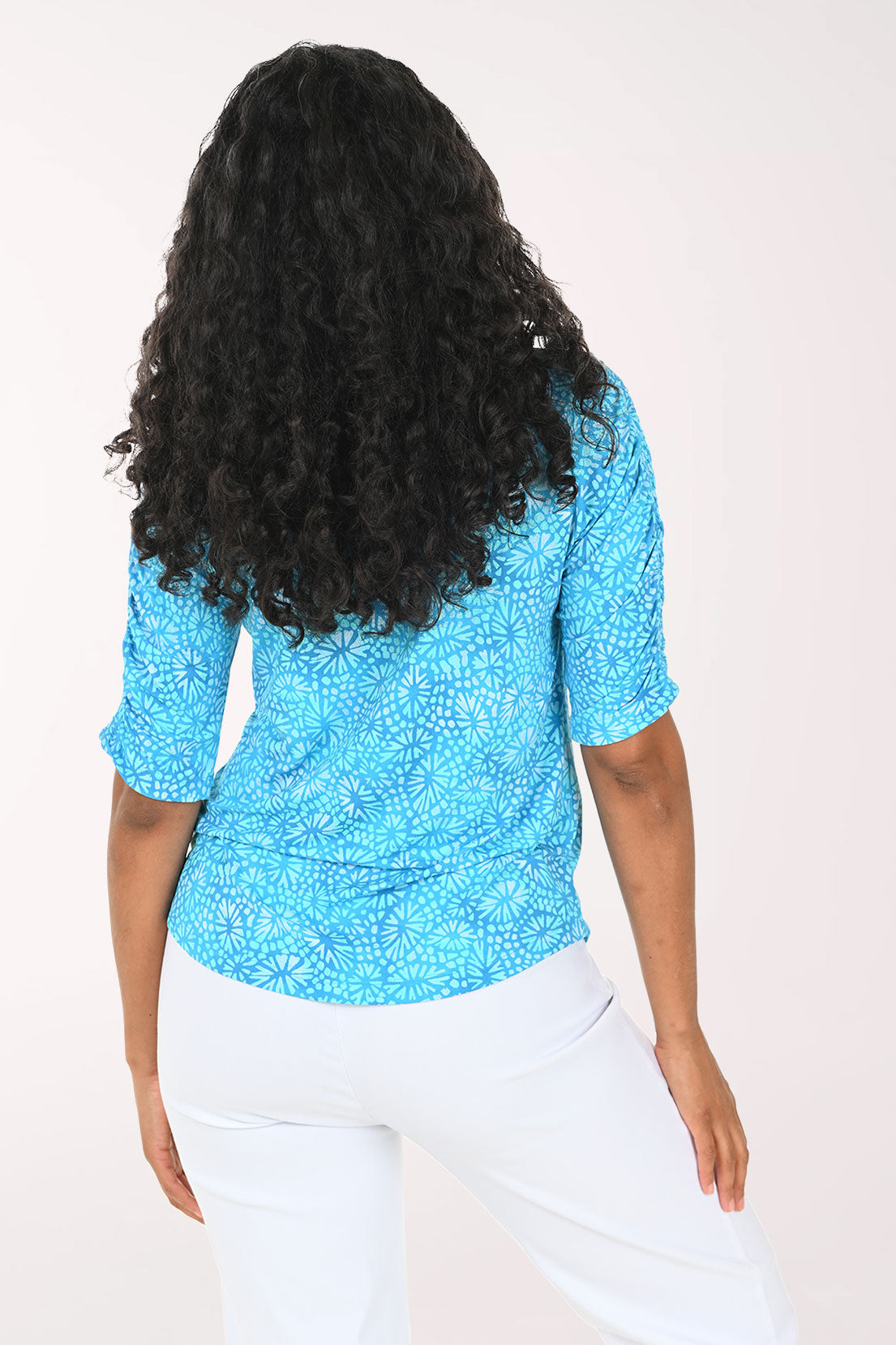 Woman wearing a blue patterned shirt against a white background