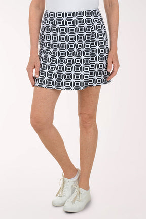 Person wearing a black and white patterned skirt on a white background