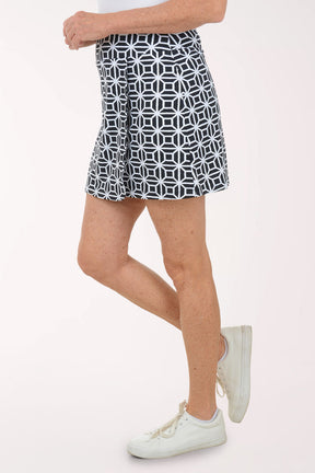 Person wearing a black and white patterned skirt on a white background