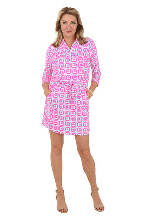 Woman wearing a pink patterned dress on a white background