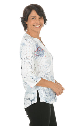 Woman wearing a white floral patterned blouse on a white background. Side shot.