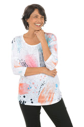 Woman wearing a colorful abstract patterned top on a white background.