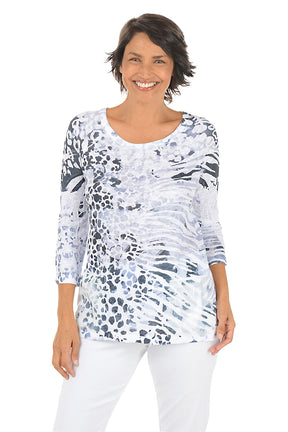 Woman wearing a patterned top and white pants on a white background