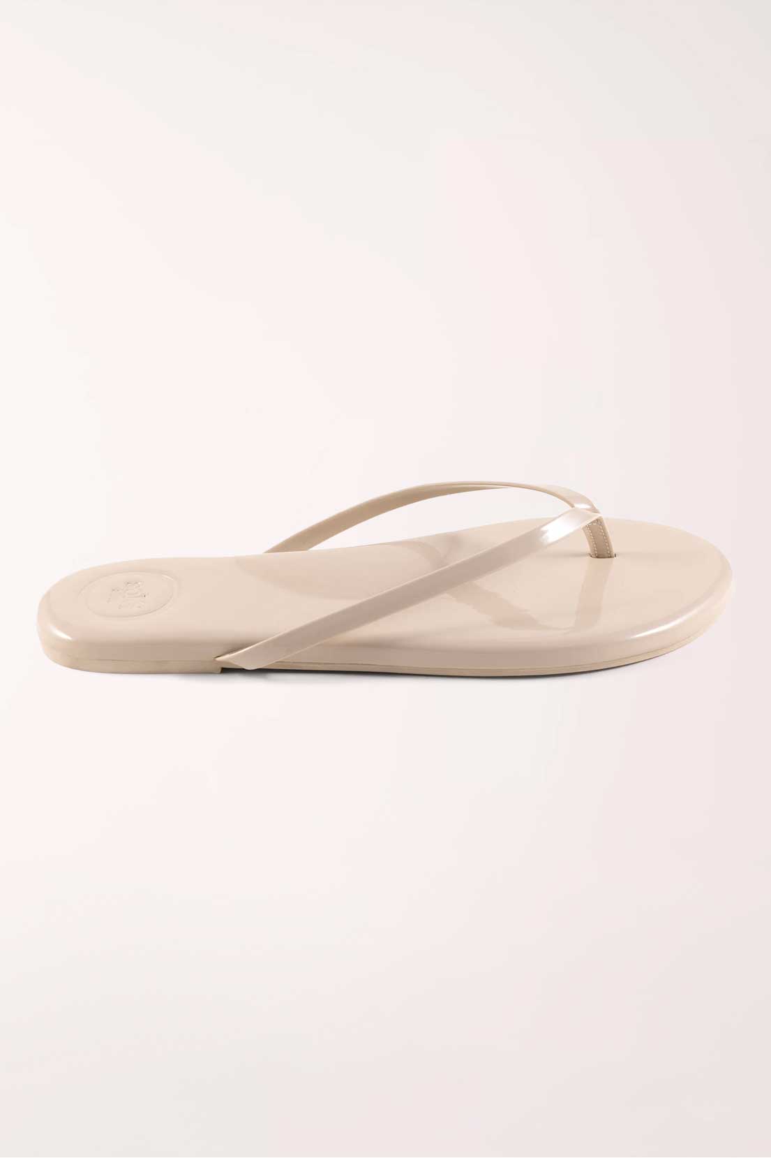 Pair of beige flip-flops on a white background