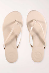 Pair of beige flip-flops on a white background