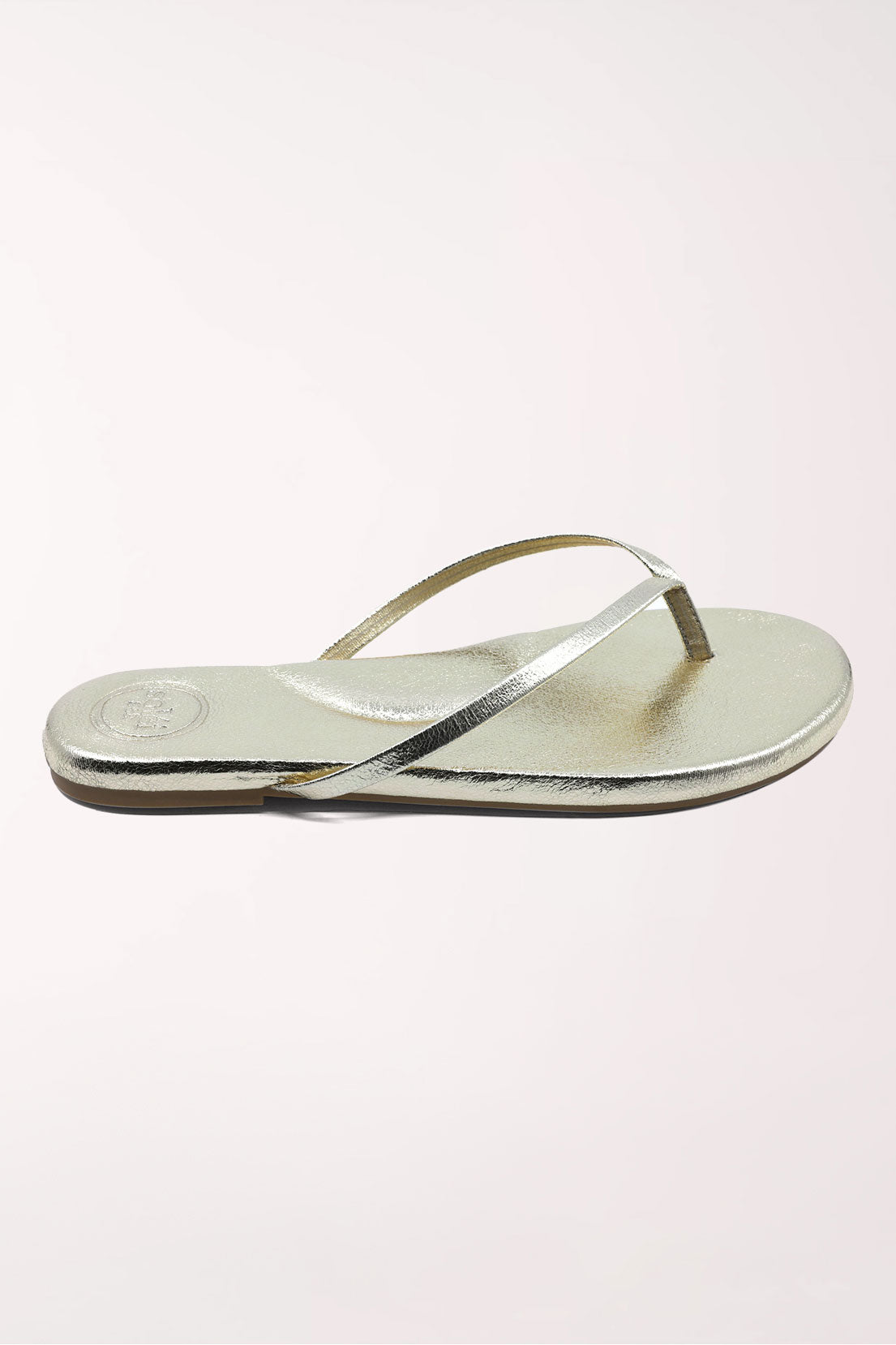 Pair of gold metallic sandals on a white background