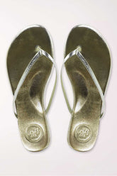 Pair of gold metallic sandals on a white background