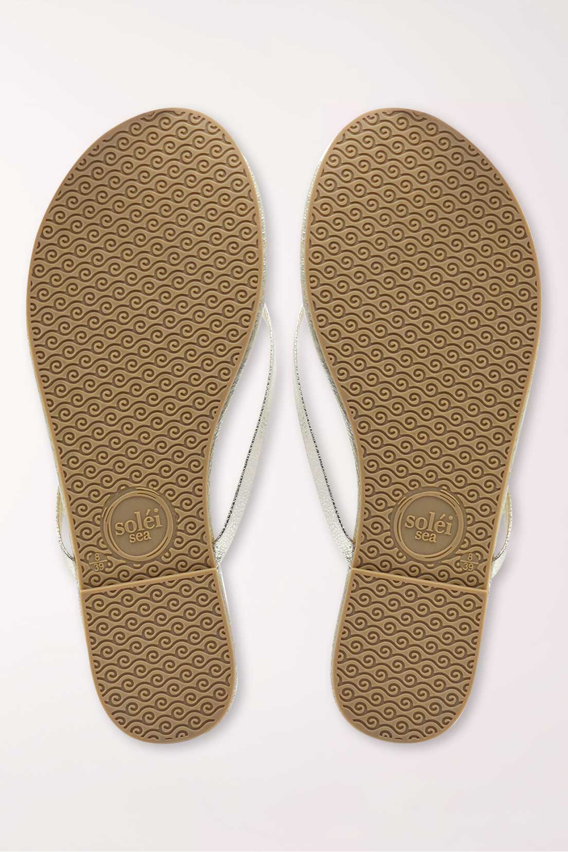 Pair of gold metallic sandals on a white background