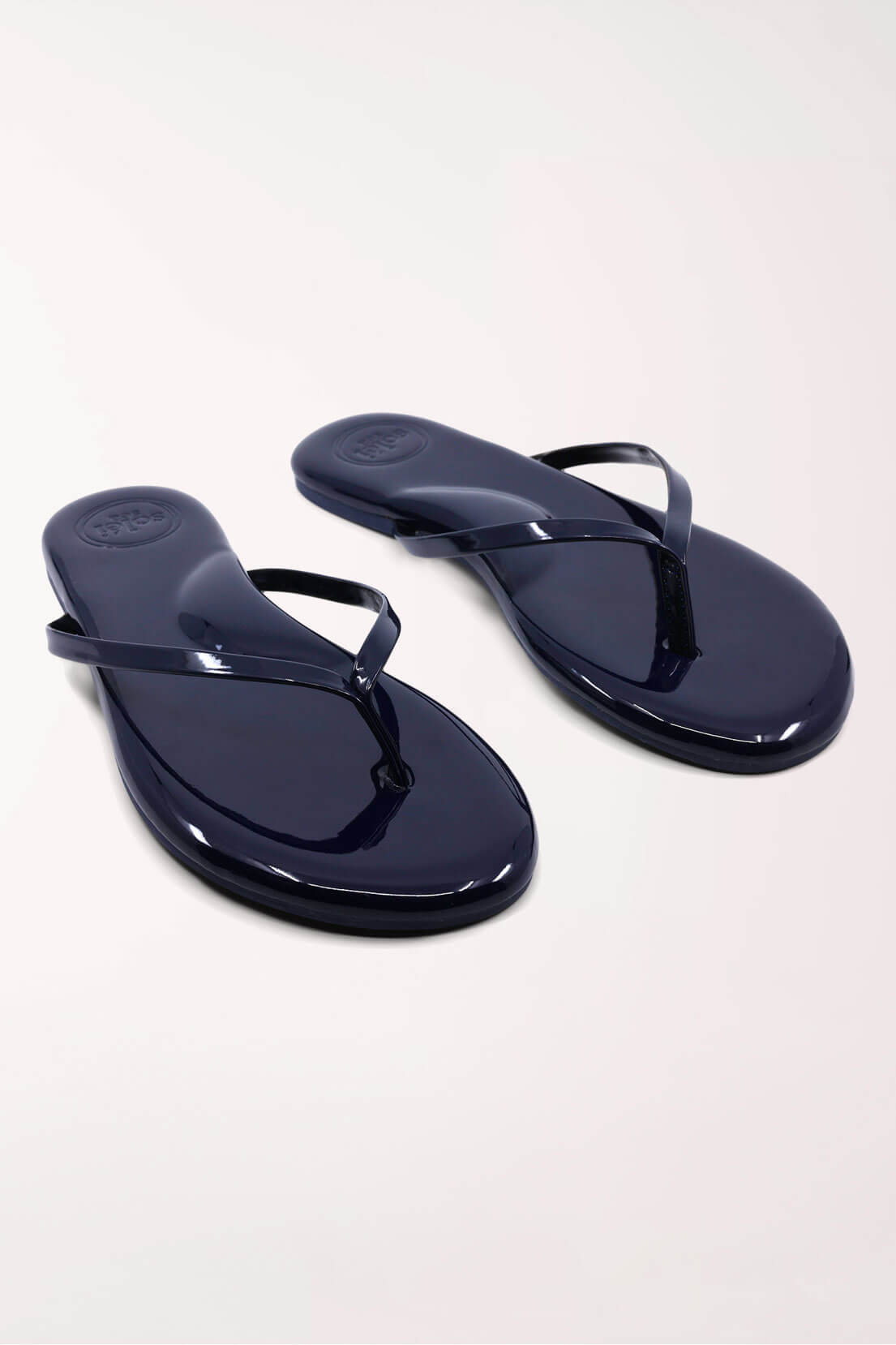 Pair of navy blue flip-flops on a white background