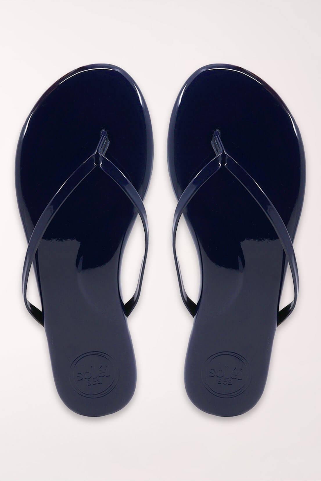 Pair of navy blue flip-flops on a white background