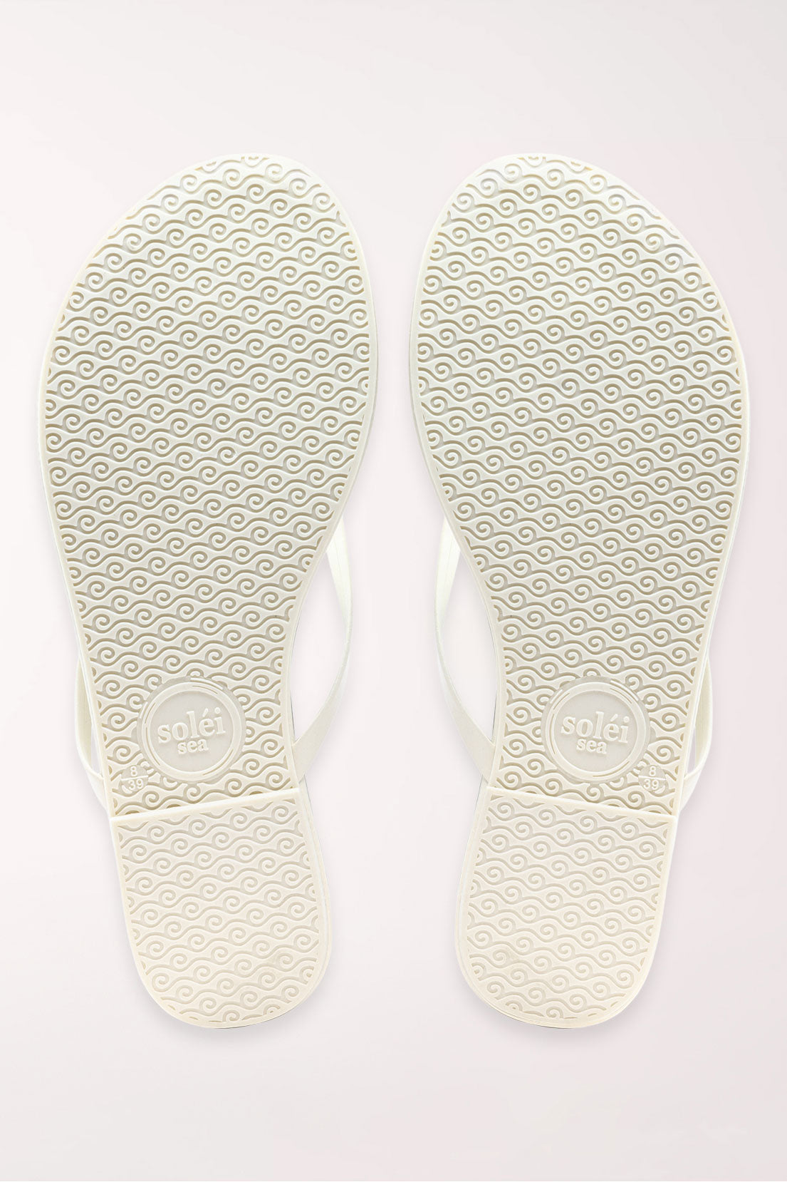 Pair of white flip-flops on a light gray background