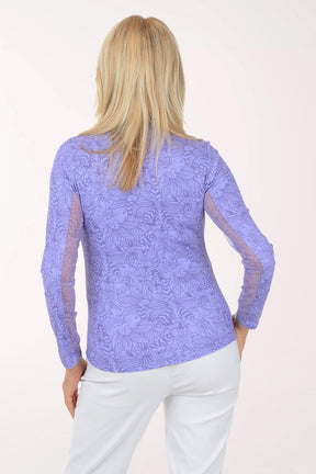 Woman wearing a purple long-sleeve top with a white background