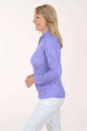 Woman wearing a purple long-sleeve top with a white background
