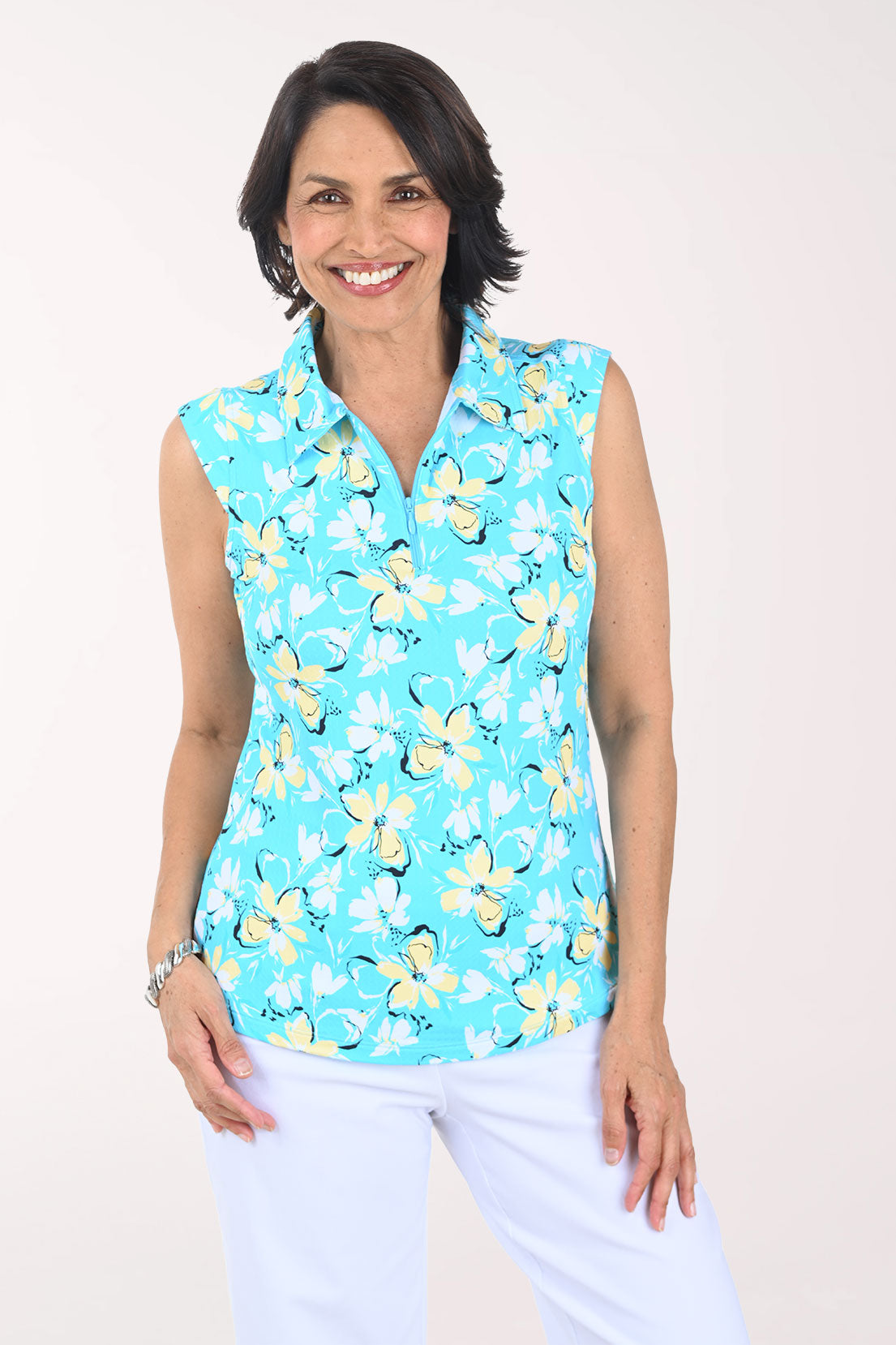 Woman wearing a sleeveless turquoise shirt with yellow floral pattern on a white background
