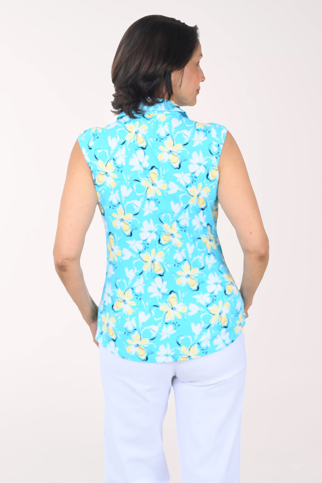 Woman wearing a sleeveless turquoise shirt with yellow floral pattern on a white background
