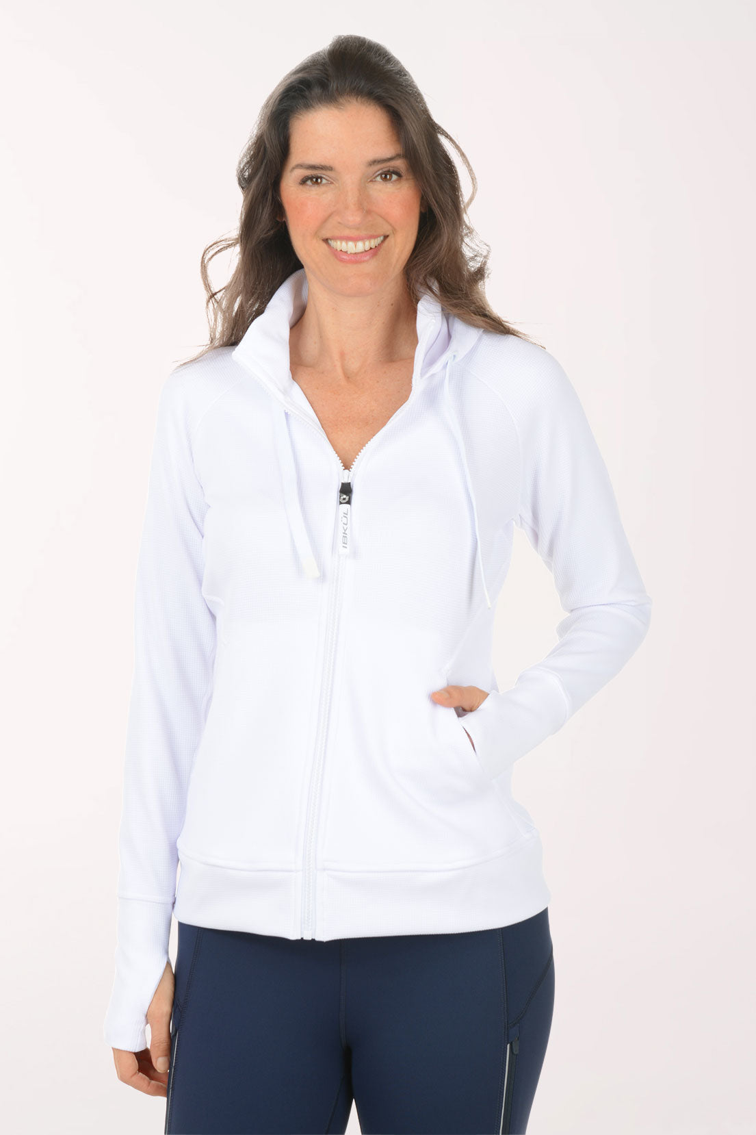A woman wearing a white zip-up  sweater.