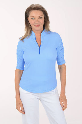 Woman wearing a blue and white checkered short-sleeve shirt with a zipper on a white background.