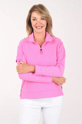 Woman wearing a pink pullover with a white background