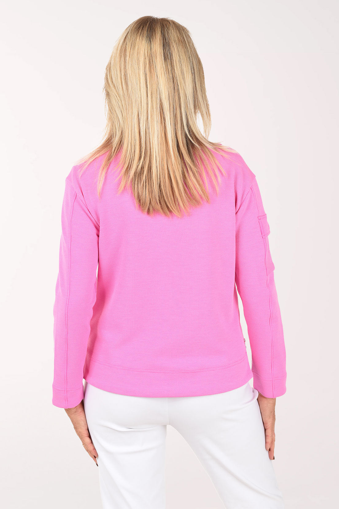 Woman wearing a pink pullover with a white background