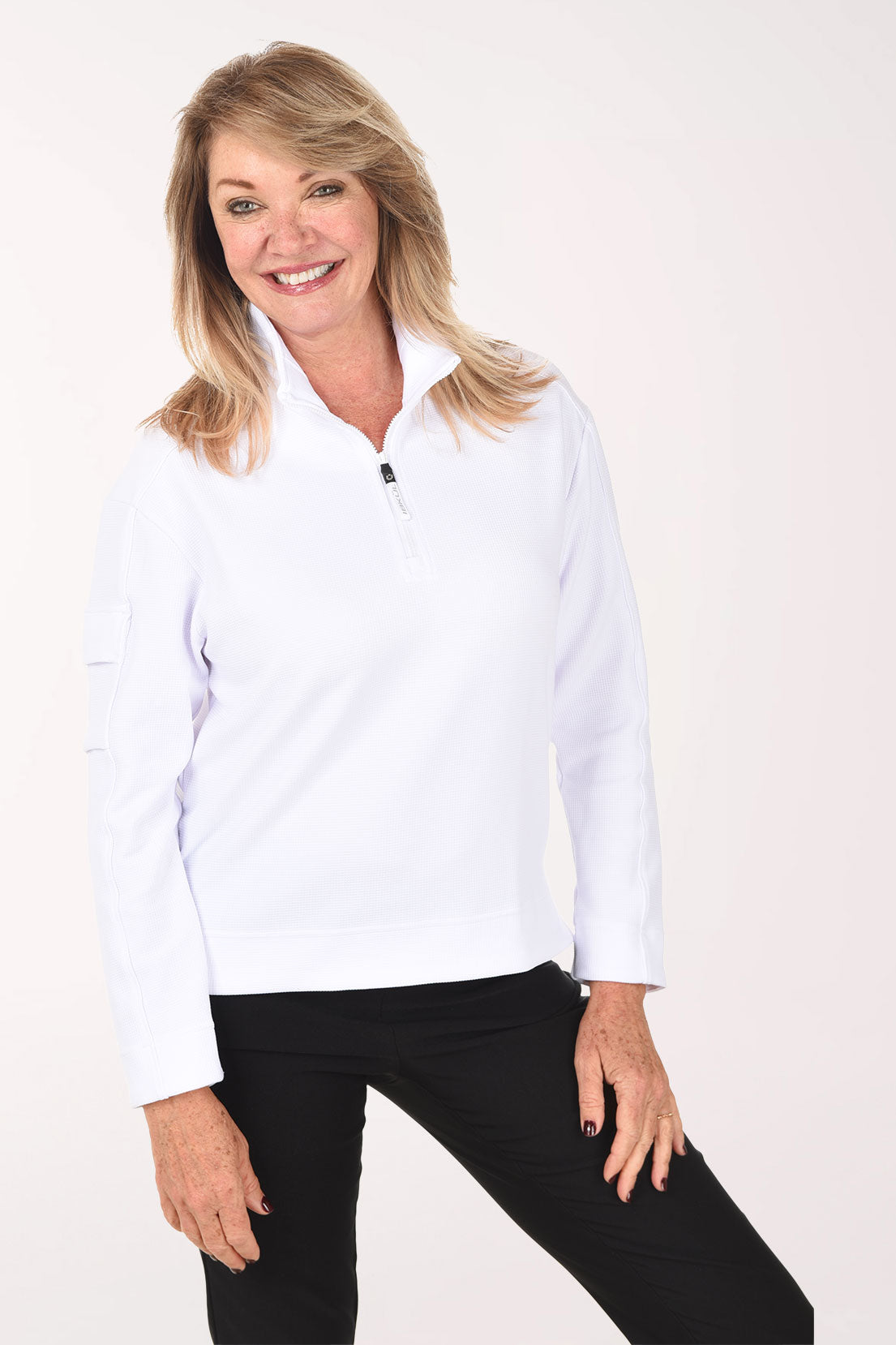 Woman wearing a white long-sleeve shirt and black pants on a white background
