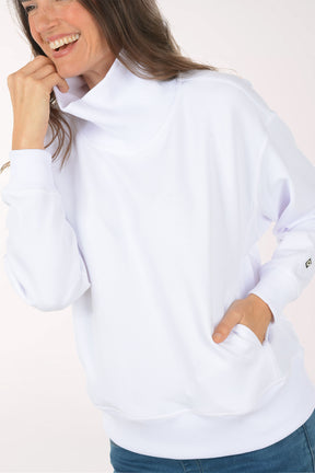 A woman wearing a white funnel neck sweater.