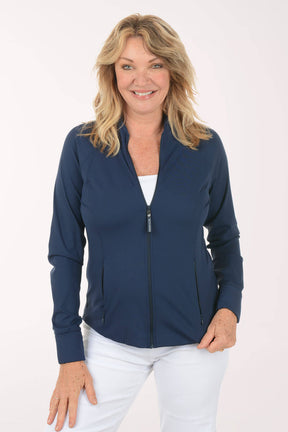 Woman wearing a navy blue zip-up jacket over a white top and pants on a white background