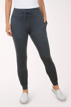 Person wearing dark navy jogger pants on a white background