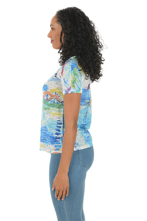 Woman wearing a colorful patterned shirt with a white background. Side shot.
