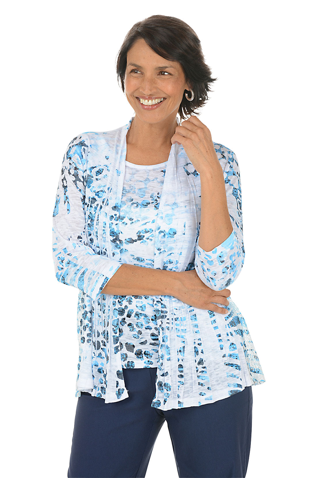 Woman wearing a blue floral cardigan over a white top on a white background.