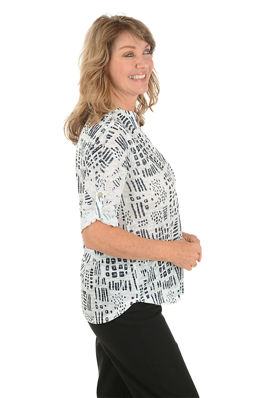 A woman wearing a 3/4 roll sleeve black and white top. Side shot.