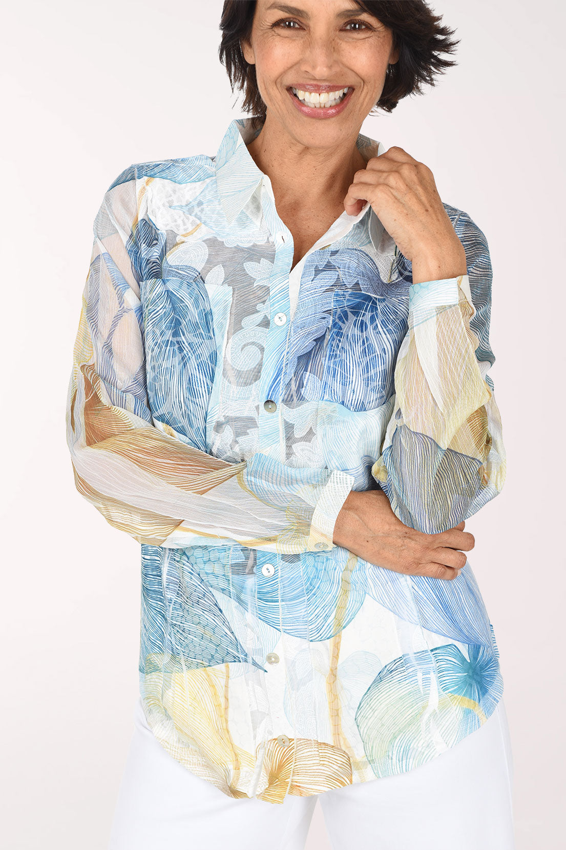 Close front view with a hand at her collar, showing the leaf sketches, chest pockets and buttoned placket