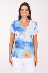 Model wearing the Impulse Daisy Blues Sequined Tee, a cobalt and sky blue painterly print with white daisies, front view