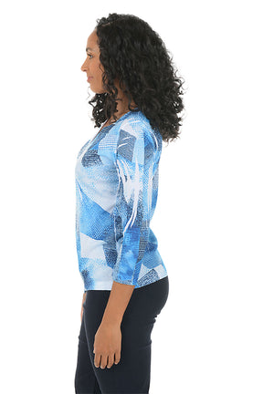 Woman wearing a blue abstract patterned top on a white background. Side shot.