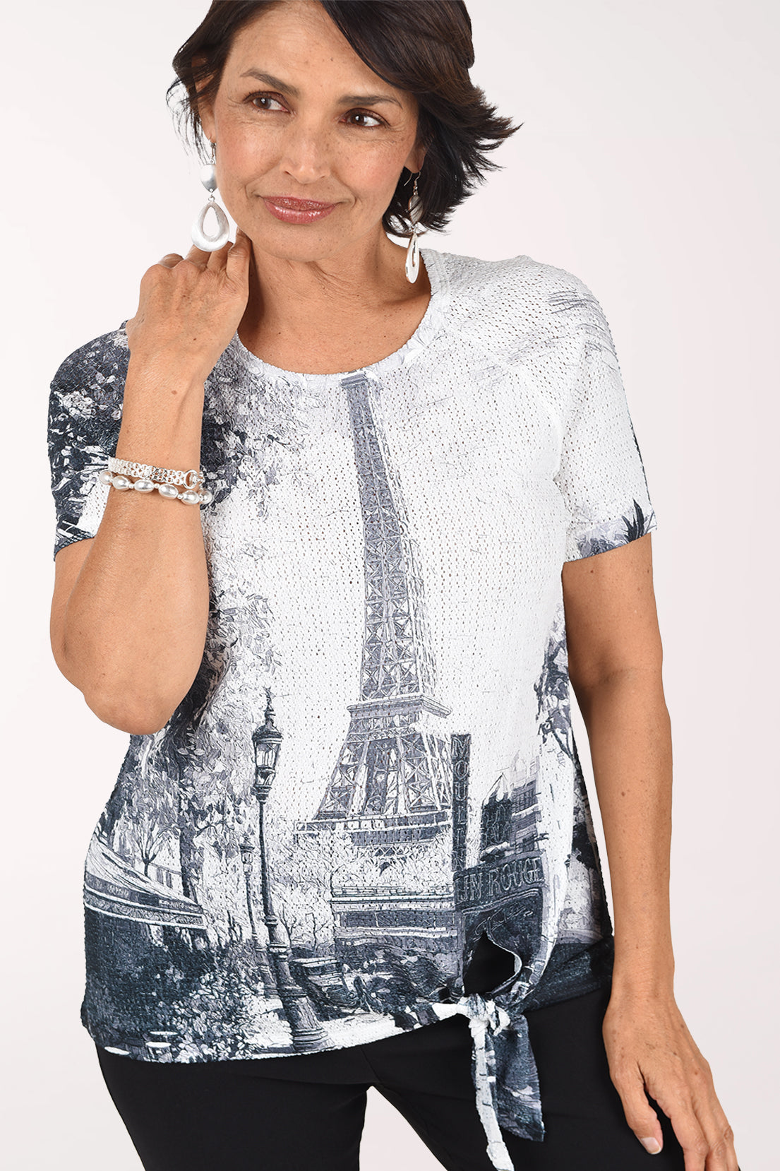 Front close-up of the Eiffel Tower top showing the eyelet texture, the tower and lampposts, and the tie at the hem.
