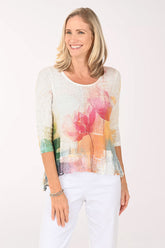 Woman wearing a colorful floral top against a white background