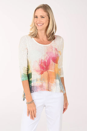 Woman wearing a colorful floral top against a white background