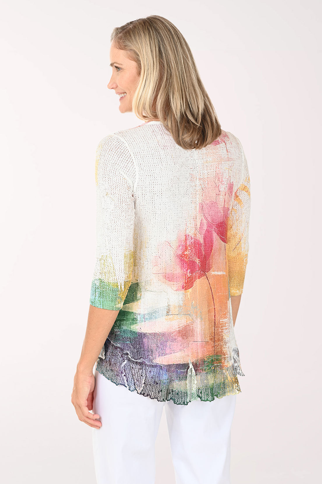 Woman wearing a colorful floral top against a white background