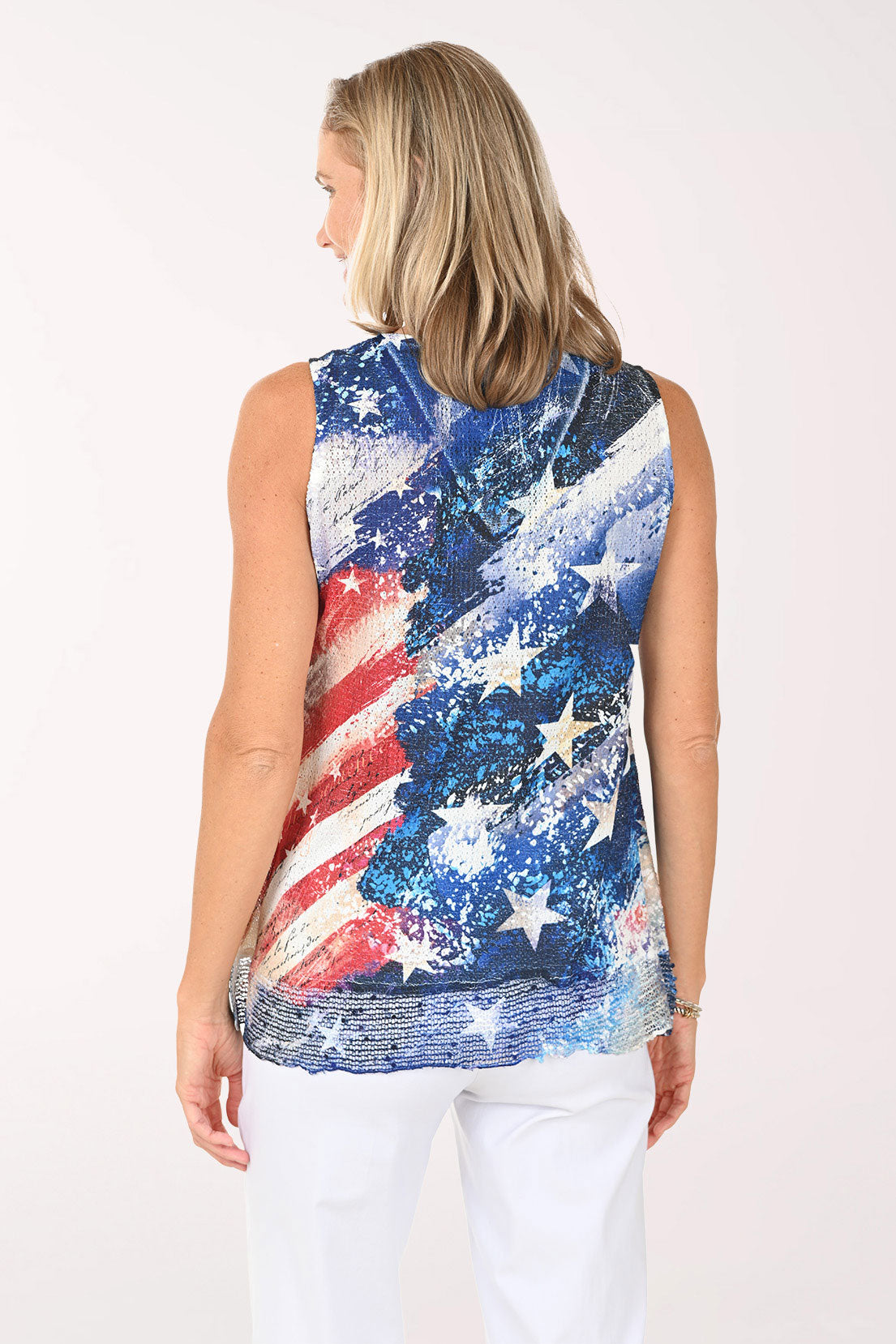 Woman wearing a sleeveless top with a colorful American flag design on a white background