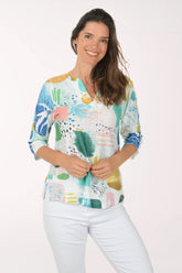 Woman wearing a colorful floral blouse against a white background