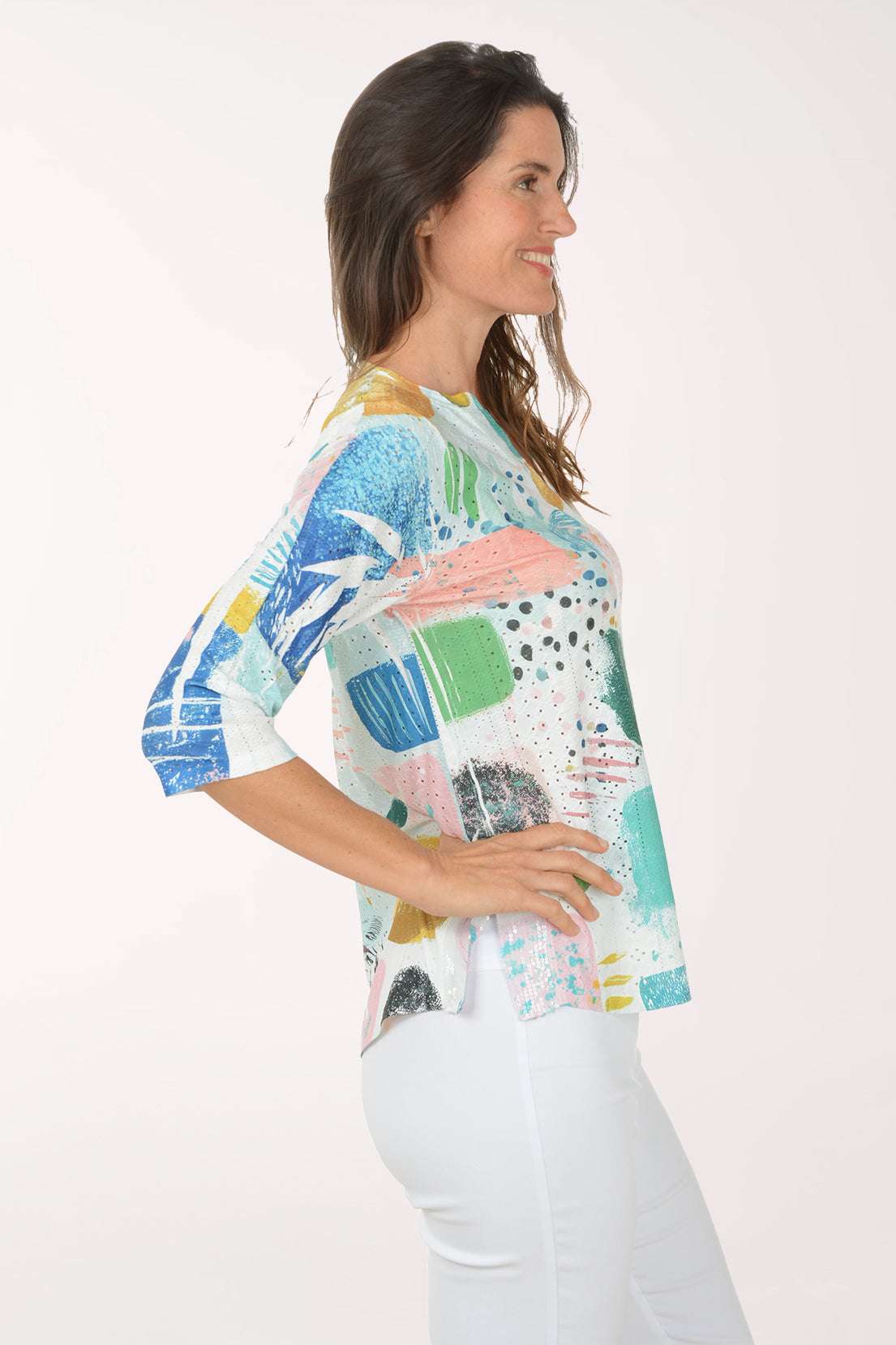 Woman wearing a colorful floral blouse against a white background