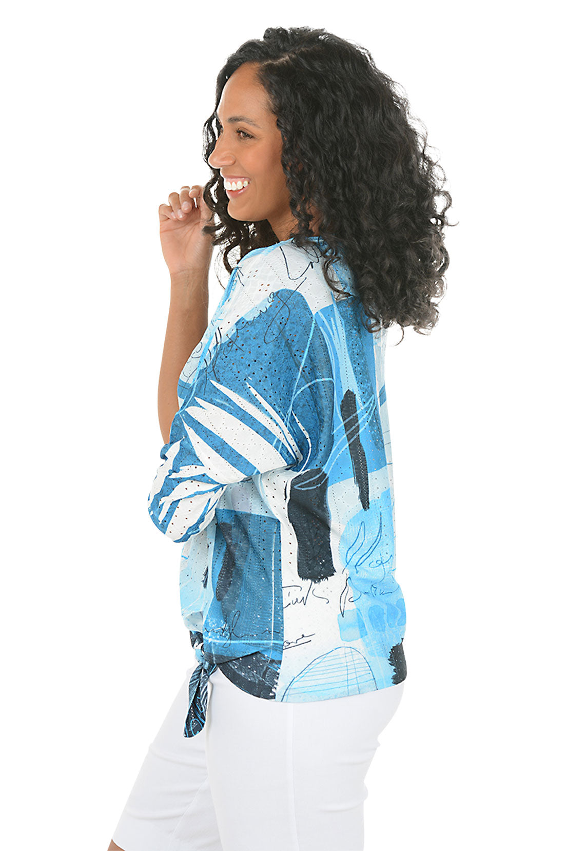 Woman wearing a blue patterned shirt on a white background. Side shot.